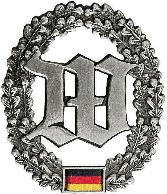 Vokietijos kariuomenės metalinis beretės ženkliukas su ąžuolo lapų vainiku ir Vokietijos vėliava.