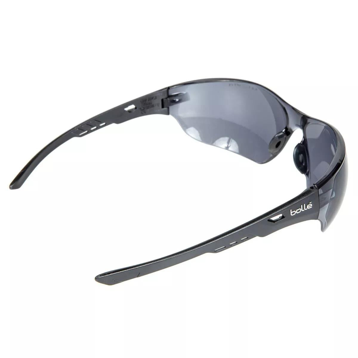 Bolle NESS taktiniai akiniai su juodais rėmeliais ir tamsintais lęšiais, rodomi iš šono, paryškinantys ergonomišką sportinį dizainą