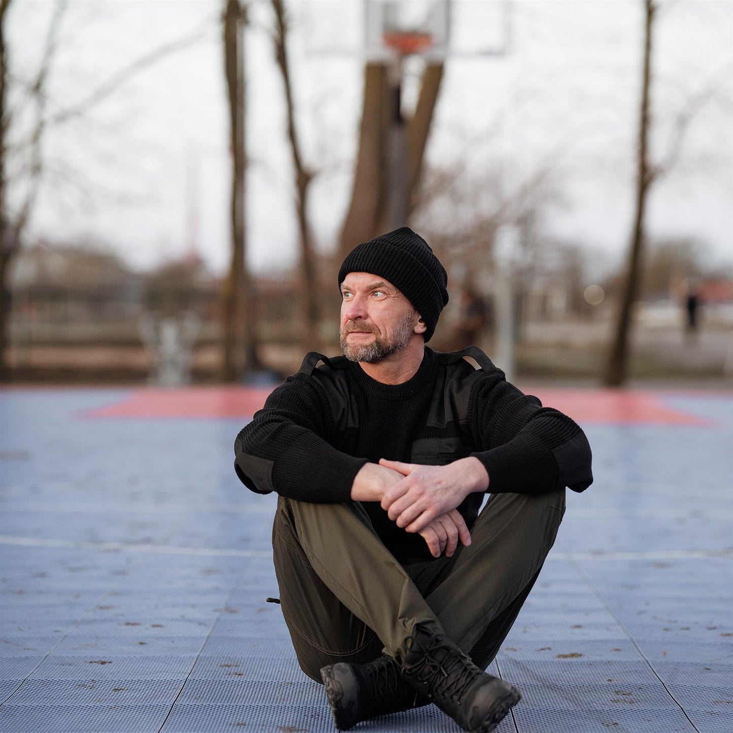 Vyras sėdi lauko aikštelėje dėvėdamas MIL-TEC Chimera MID lauko batus žygiams lengvi.