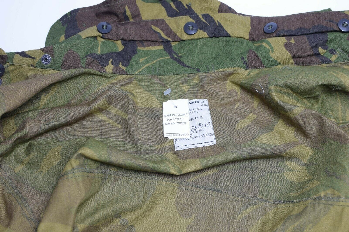 Olandijos kariuomenės parka stiliaus M65 striukė DPM marginimas su etiketės žyma ir kamufliažo raštu.