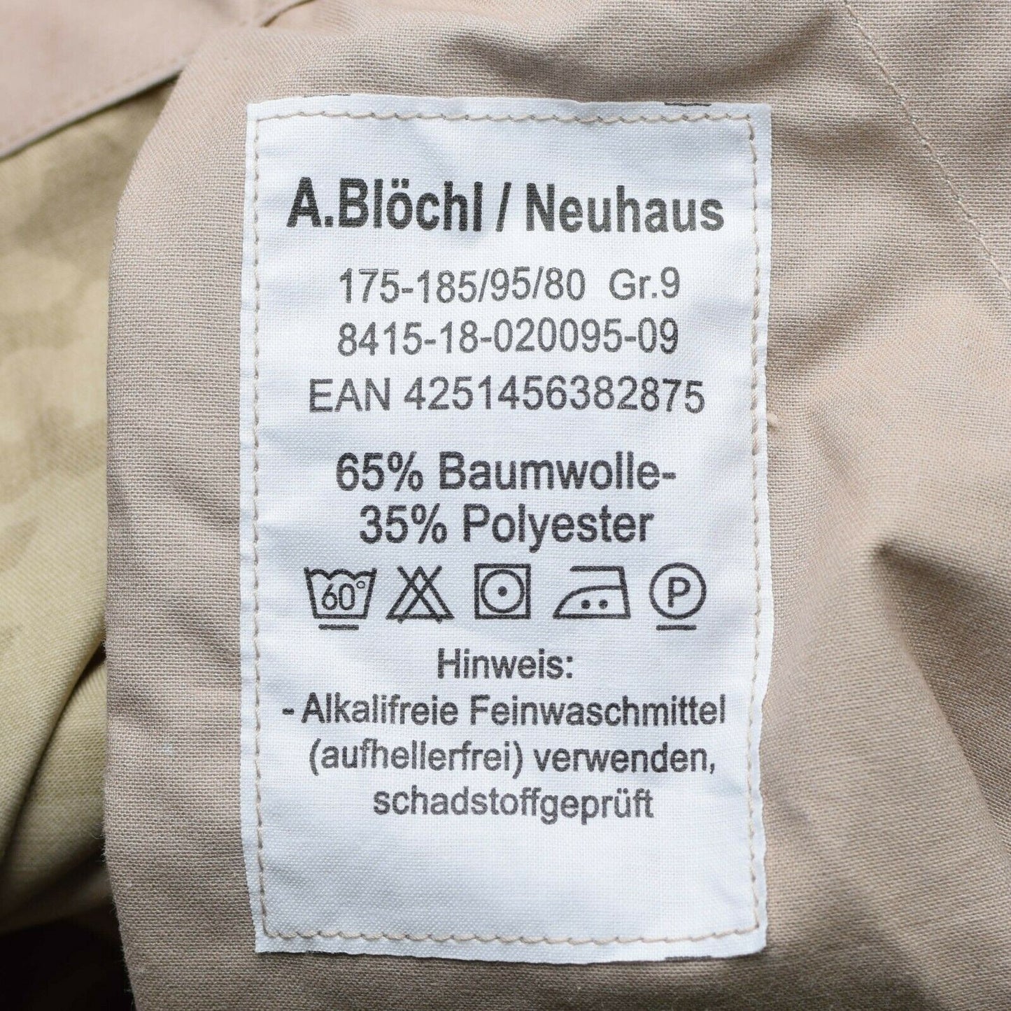 Vokietijos kariuomenės lauko kelnės Desert marginimo audinio etiketė su sudėtimi ir priežiūros instrukcijomis.