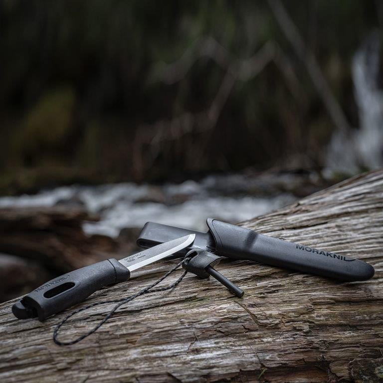 MORAKNIV Companion Spark universalus fiksuotas peilis su ugnies skeltuvu ant medžio gamtoje.