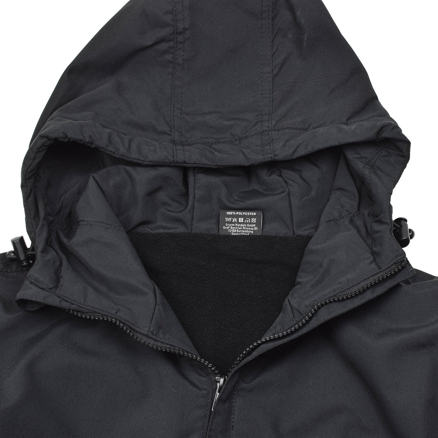 MIL-TEC Anorak stiliaus striukė juodos spalvos su elastingu gobtuvu ir tvirtos poliesterio medžiagos vėjo apsauga.