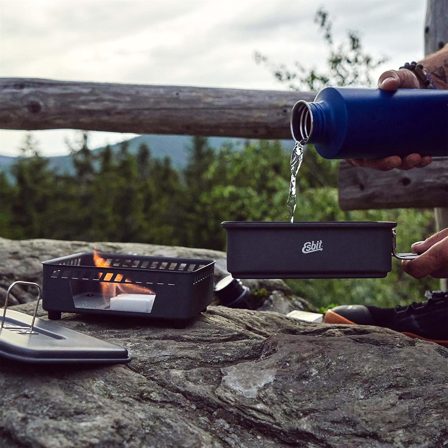 ESBIT kieto kuro viryklė su 1100ml indu gaminimui lauke, degantis kieto kuro tabletėmis ir pilamas vanduo į puodą.