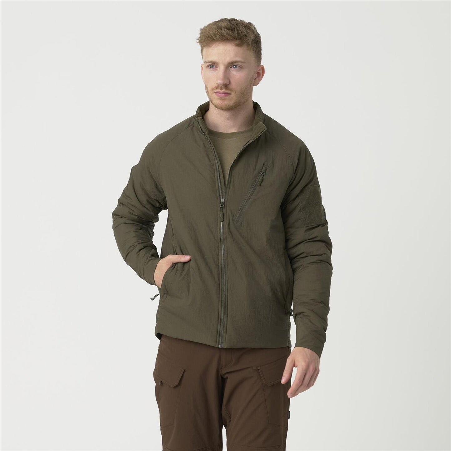 Vyras dėvi Helikon-Tex Wolfhound striukę su Climashield izoliacija ir YKK užtrauktuku.
