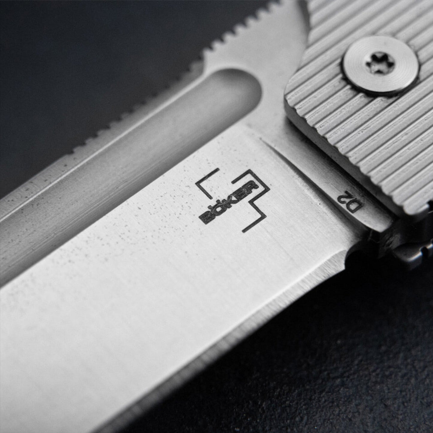 Boker Plus BabyX sulankstomas peilis iš D2 plieno, artimas geležtės ir rankenos detalės vaizdas.