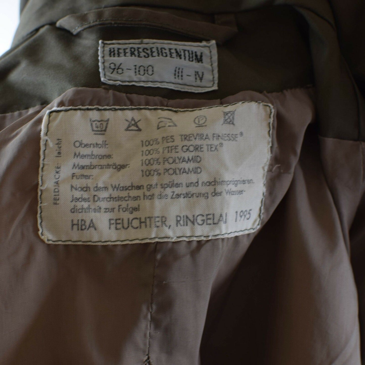 Austrijos kariuomenes M65 striukes etiketė su skalbimo instrukcijomis ir medžiagos sudėtimi GoreTex audinyje