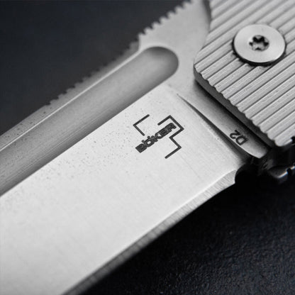 Boker Plus BabyX sulankstomas peilis iš D2 plieno, artimas geležtės ir rankenos detalės vaizdas.